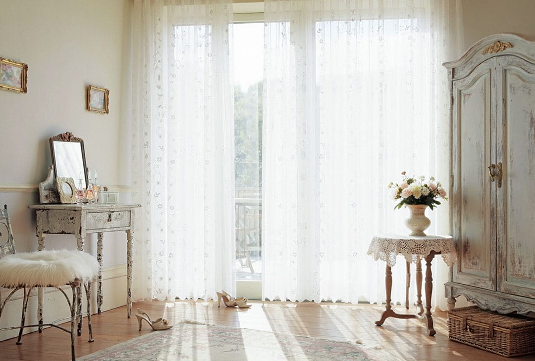 自然光を取り込むアンティークテイストの部屋とレースカーテン